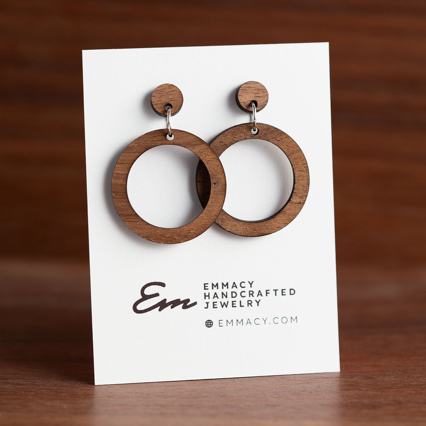 Laser cut wooden dangle earrings in the shape of a hoop.