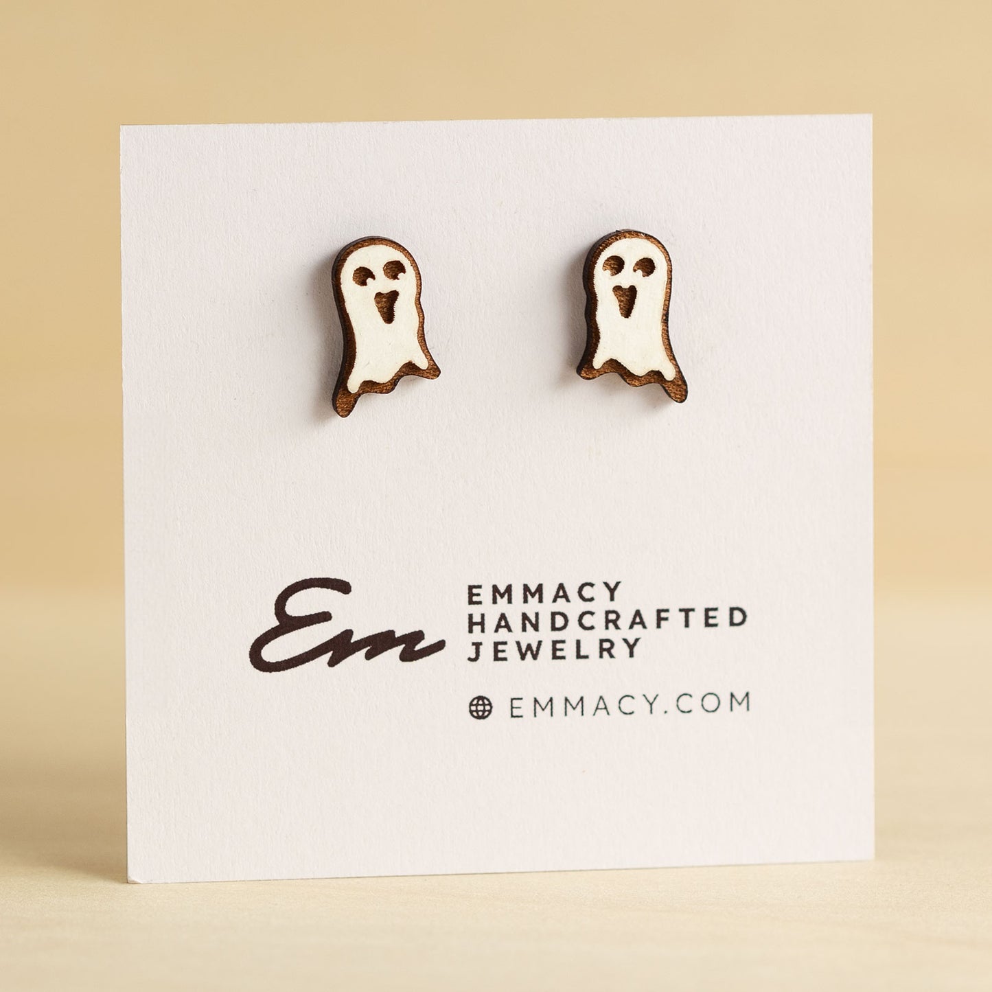 Laser cut wooden stud earrings in the shape of a ghost painted white.