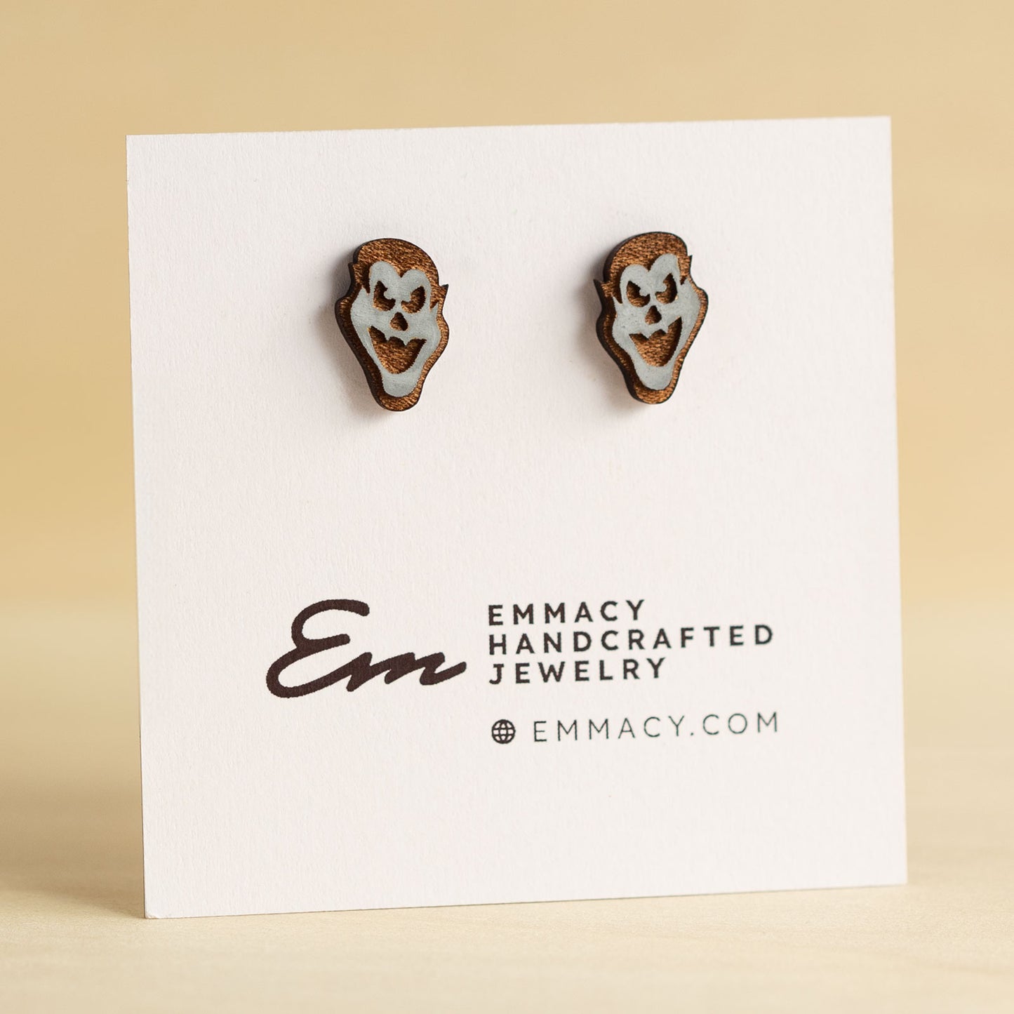 Laser cut wooden stud earrings in the shape of a vampire face painted gray.