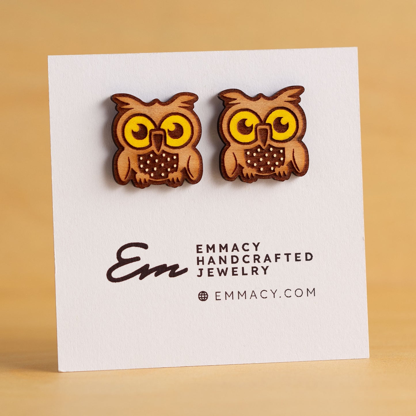 Laser cut wooden stud earrings in the shape of an own with yellow painted eyes.