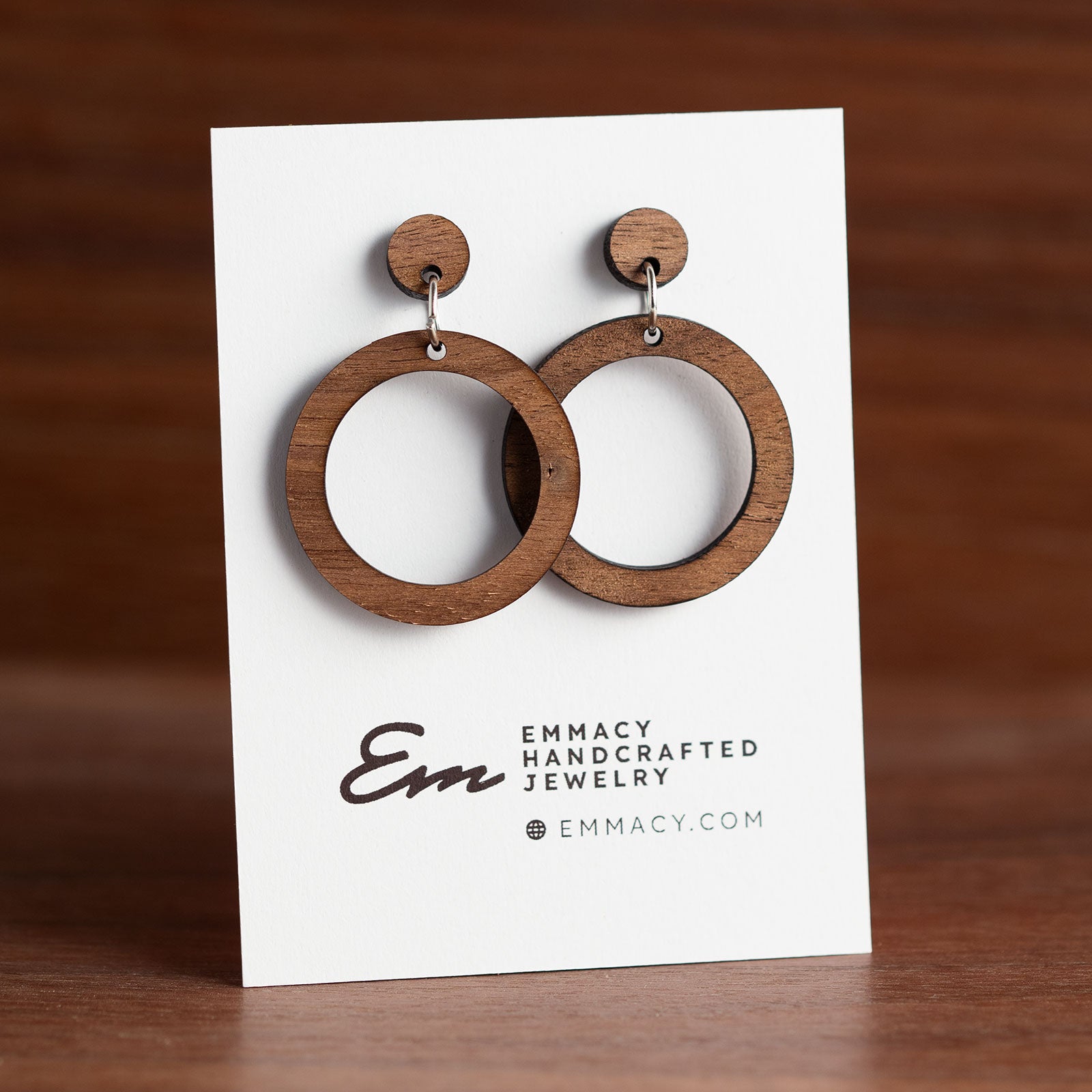 Laser cut wooden dangle earrings in the shape of a hoop.