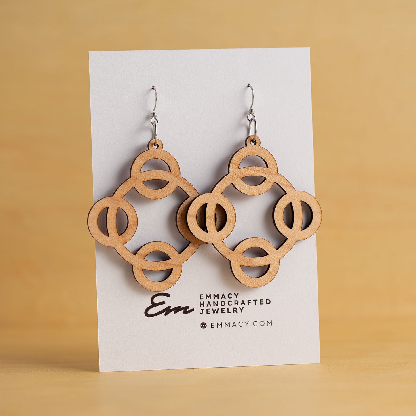 Laser cut wooden dangle earrings cut in the shape of four circles around a large center circle.