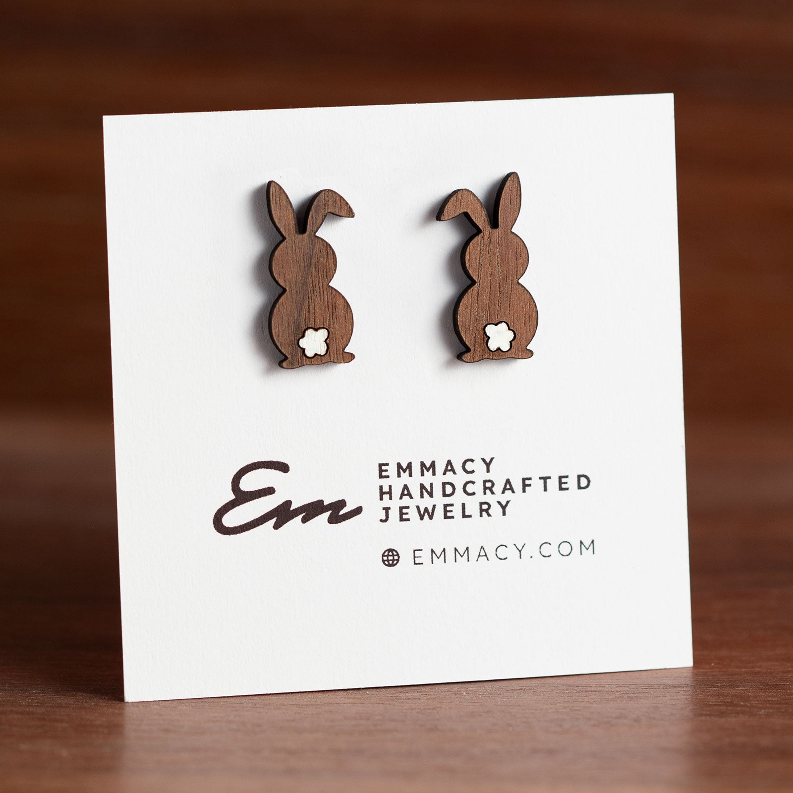 Laser cut wooden stud earrings in the shape of a rabbit with a white painted tail.