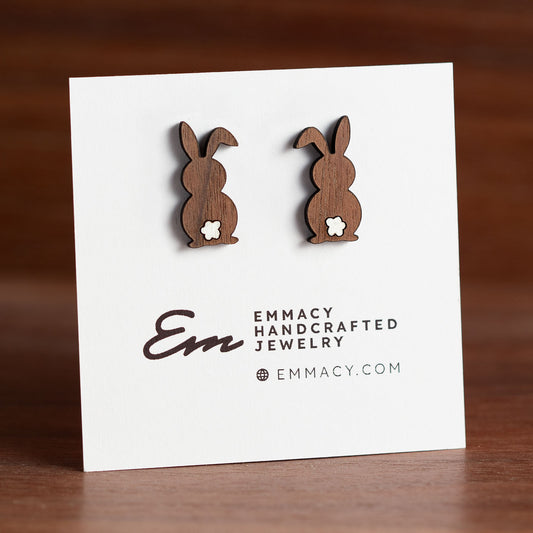 Laser cut wooden stud earrings in the shape of a rabbit with a white painted tail.