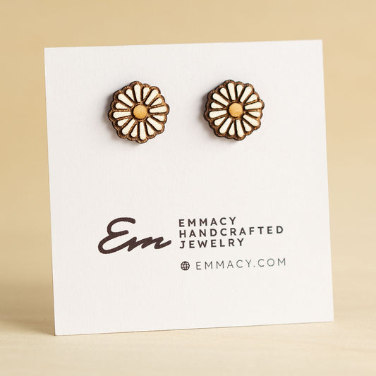 Laser cut wooden stud earrings cut in the shape of a daisy with white painted petals.