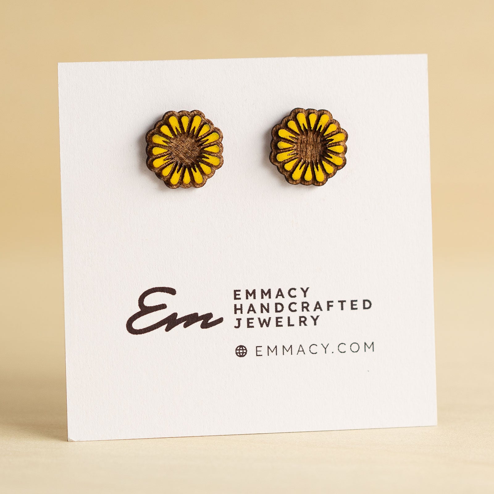 Laser cut wooden stud earrings in the shape of a sunflower with yellow painted petals.