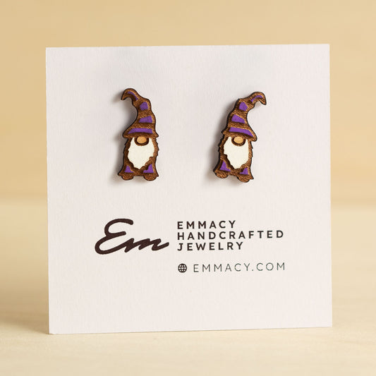 Laser cut wooden stud earrings cut in the shape of a gnome painted purple and white.