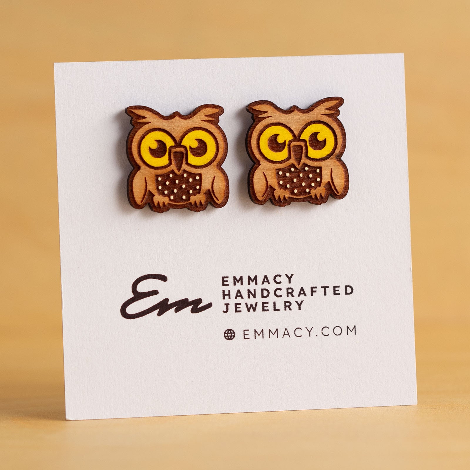 Laser cut wooden stud earrings in the shape of an own with yellow painted eyes.